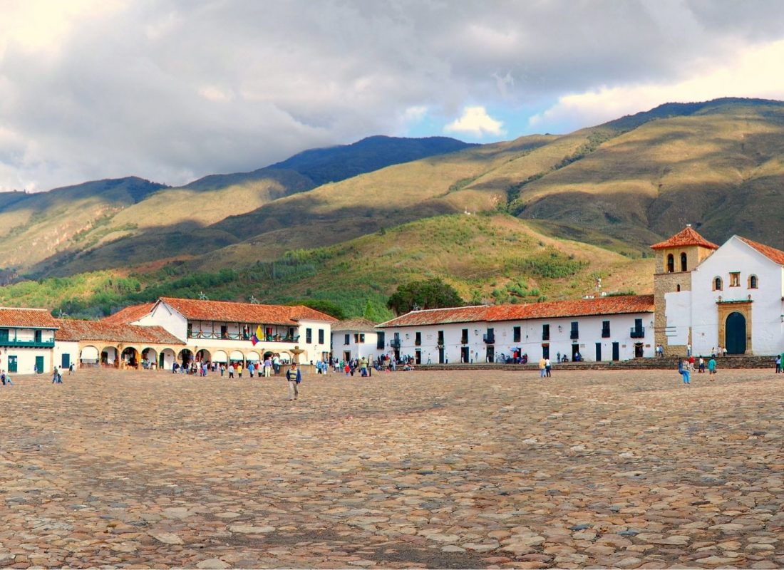 The main square of Villa de Leyva, one of the biggest colonial square in South America, with Nuestra Señora del Rosario church on the right hand side and the beautiful mountains in the background.